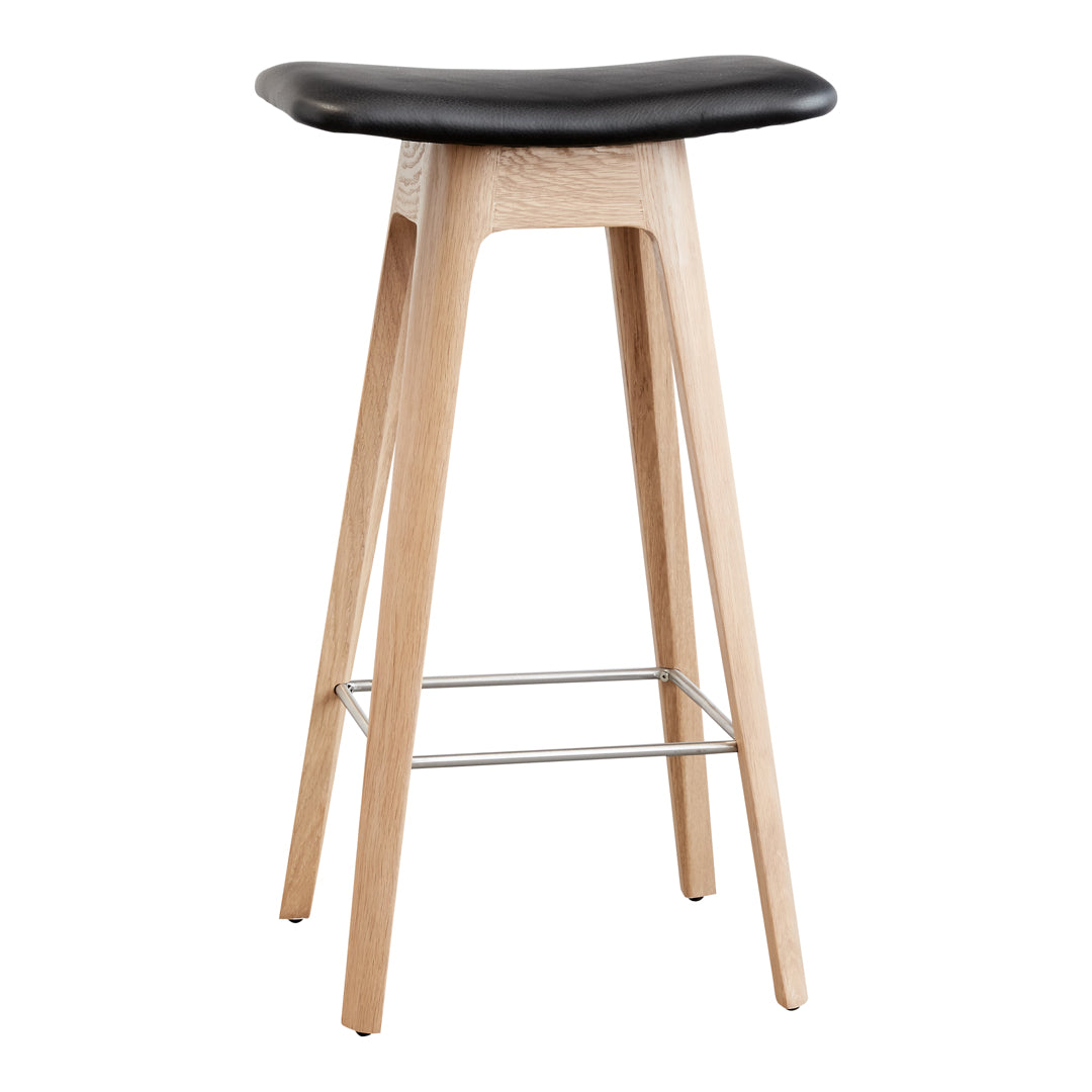 Black cushioned seat with natural wood legs and silver footrest, featuring a sleek, minimalist design.