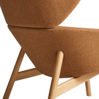 "Textured brown fabric accent chair with organic shape and light wood legs, perfect for modern decor."