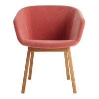 Pink velvet accent chair with smooth, curved lines and natural wood legs. Modern design for stylish interiors.