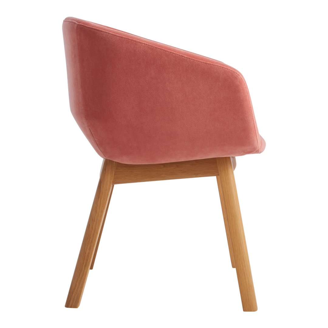 Stylish pink velvet chair with wooden legs, featuring a smooth, modern design. Perfect for contemporary home decor.