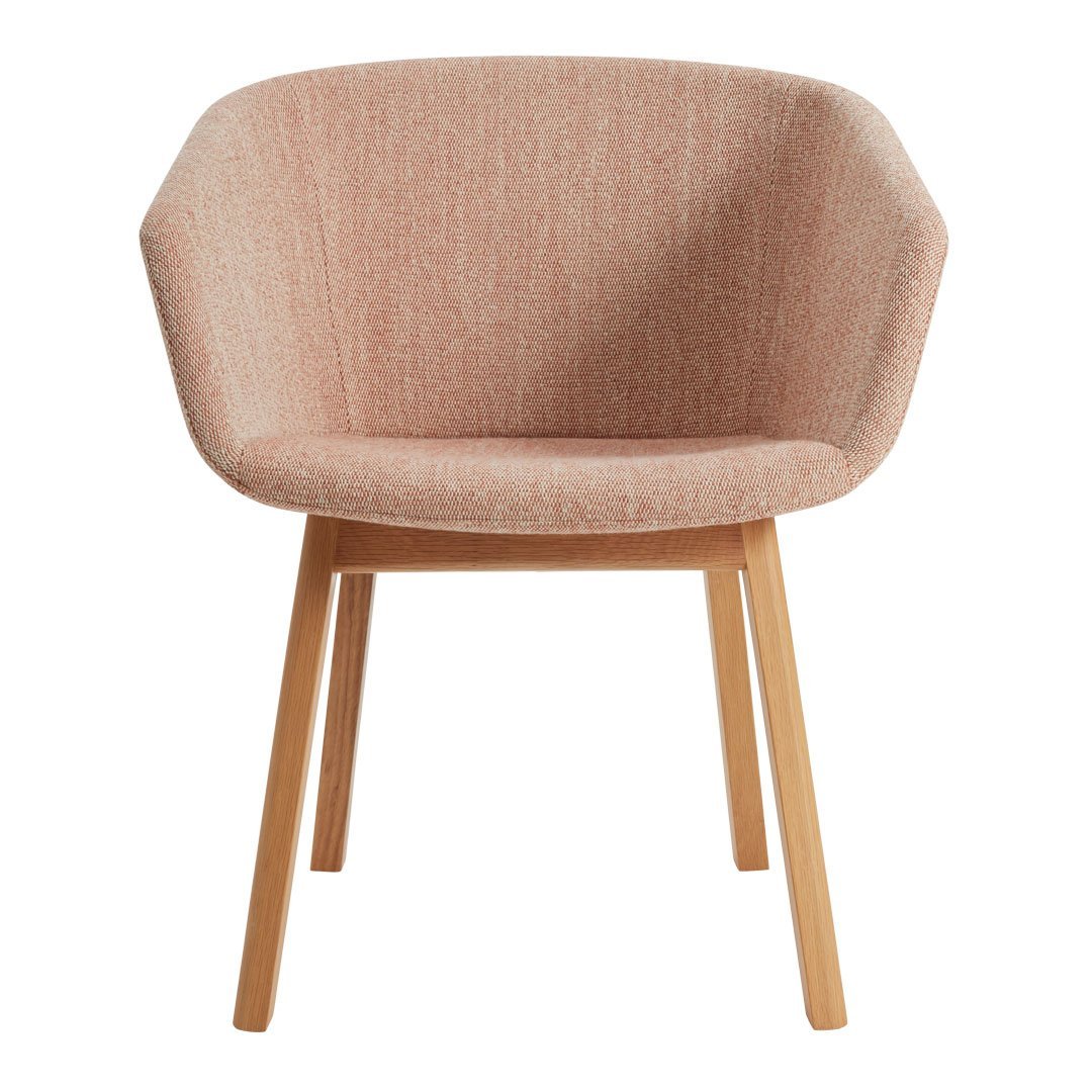 Pink textured upholstery armchair with natural wood legs, featuring a modern geometric shape.