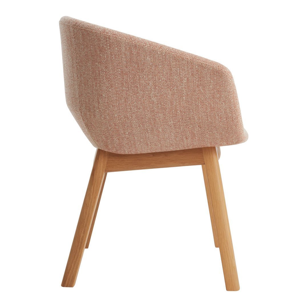 Soft pink upholstered chair with a textured pattern and wooden legs, offering a modern, minimalist aesthetic.