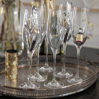 Clear champagne flutes on a silver tray, featuring elegant, elongated shapes and sparkling clarity.