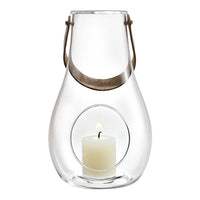 Clear glass lantern with a silver handle and a white candle inside, featuring a minimalist design and smooth contours.