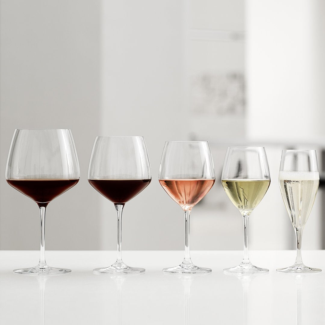 Set of five elegant wine glasses: rich red, blush pink, light yellow, and crisp white varieties on a minimalist background.