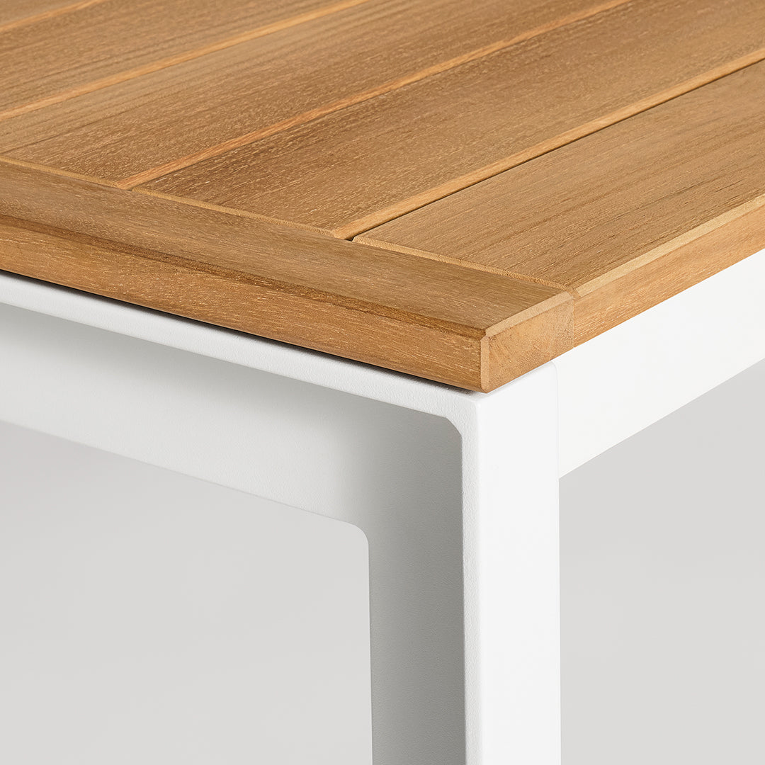 Close-up of a wooden tabletop with a natural finish, paired with a sleek white metal frame.
