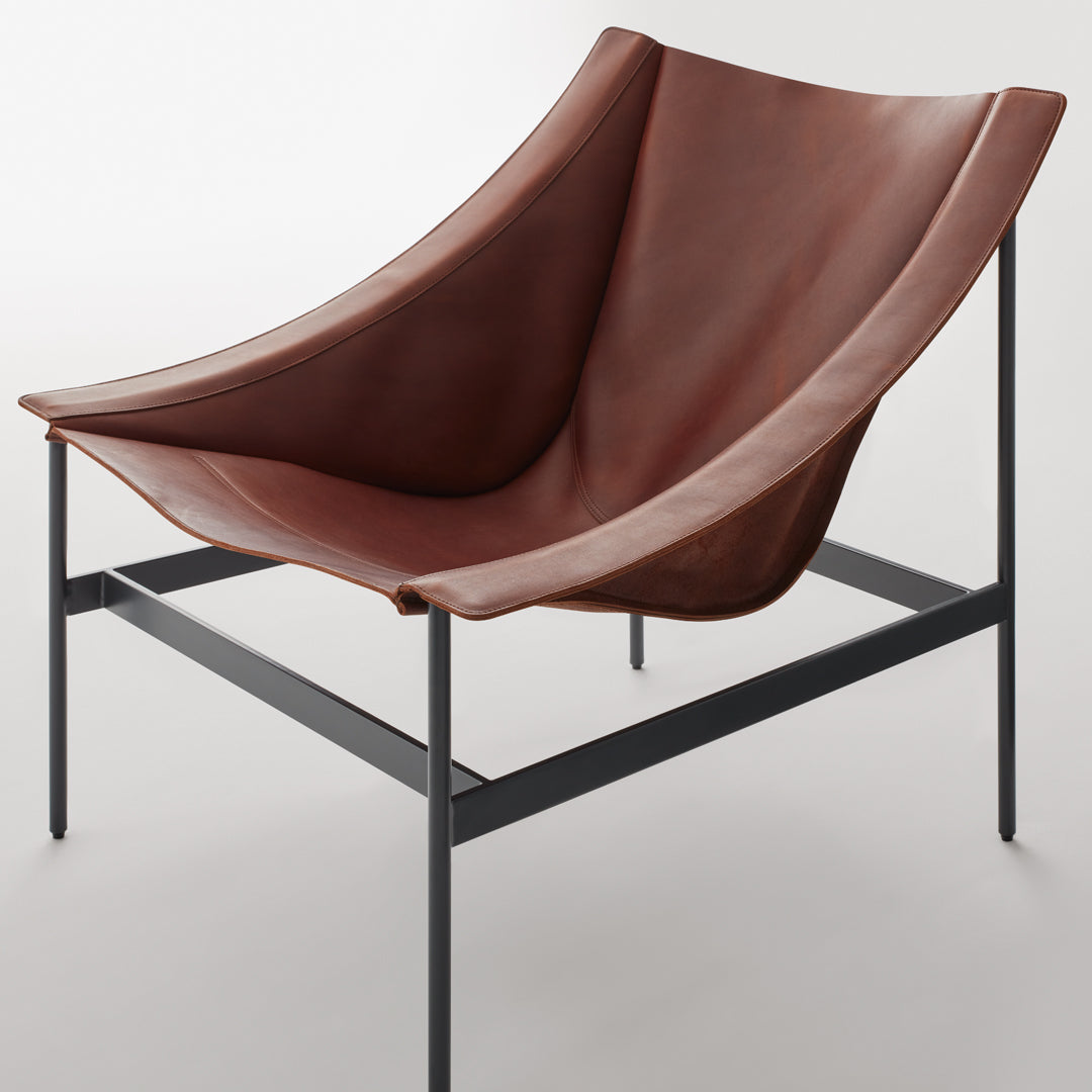 Modern brown leather chair with a smooth, curved design and black metal frame, perfect for stylish decor.