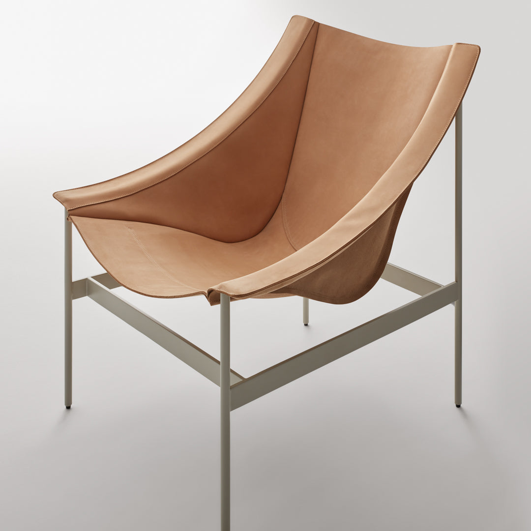 Modern curved chair in warm tan leather with a minimalist metal frame. Elegant design with smooth texture.