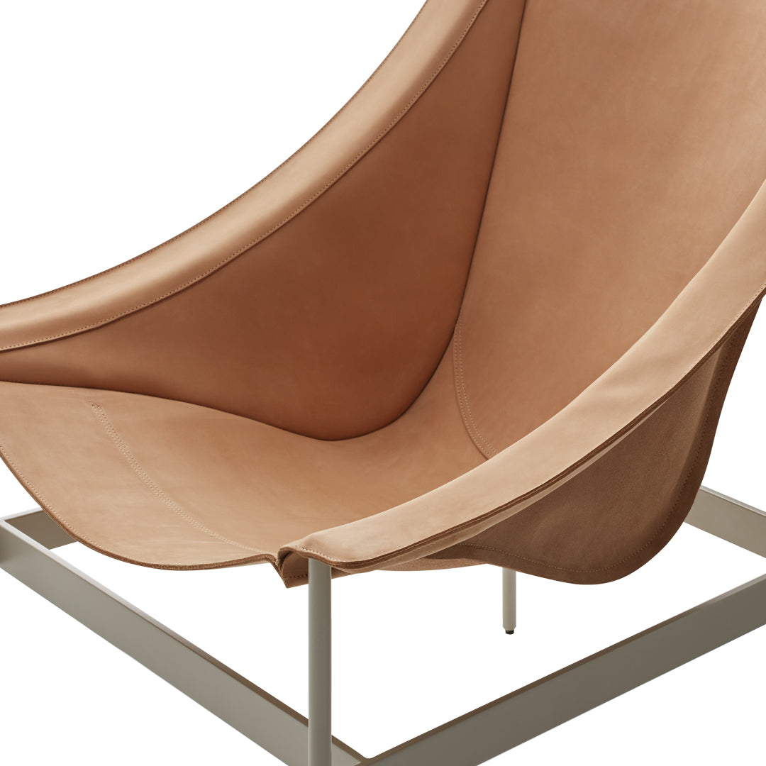 Tan leather seat with smooth curves in a minimalist design, featuring a sleek light gray metal frame.