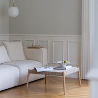 Light gray walls, white furniture, and a patterned wooden coffee table with a natural finish in a serene living room setting.