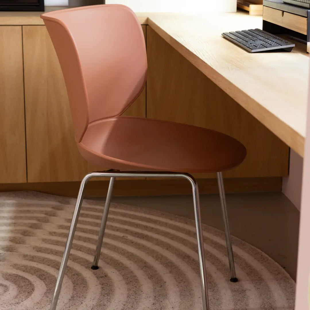 Brown and pink modern chair on a patterned beige rug, enhancing a stylish workspace decor.