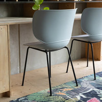 Gray modern chairs with sleek black legs, set against a colorful patterned rug, adding a contemporary touch to any space.