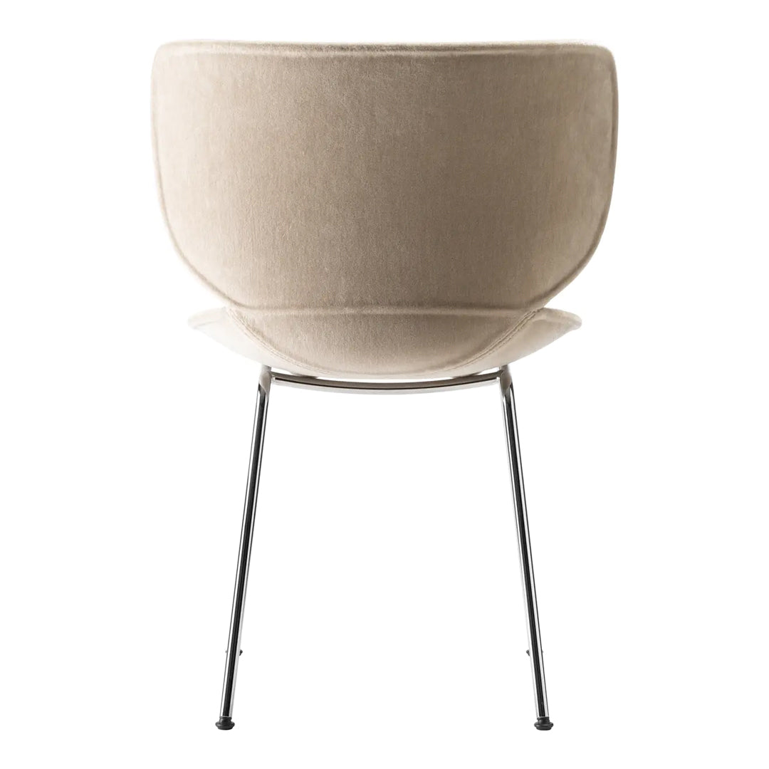 Beige upholstered chair with a smooth, curved shape and sleek metallic legs. Minimalist design with neutral tones.