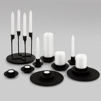 Minimalist candle holder set in black and white with varying shapes and heights for elegant decor.