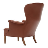 Brown leather armchair with smooth, sleek design and elegant wooden legs. Stylish and contemporary home decor.