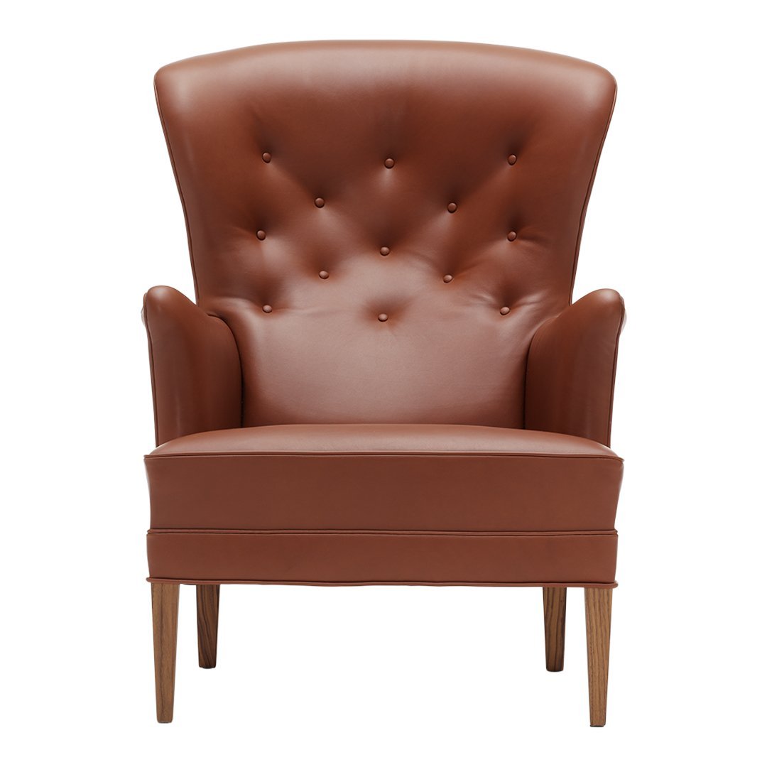 Brown leather accent chair with tufted back and sleek wooden legs, ideal for modern decor.