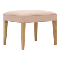 Soft pink upholstered ottoman with natural wood legs, featuring a simple, contemporary design.