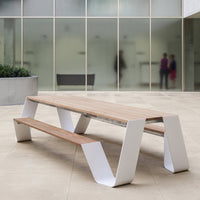 Modern picnic table with a natural wood top and sleek white metal base, featuring clean lines and minimalistic design.