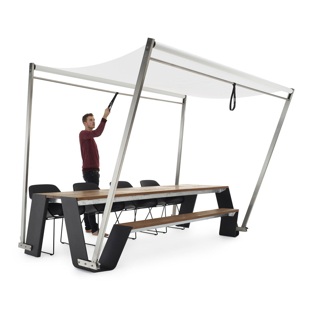 White canopy with a sleek, modern design, supported by silver metal frames and complemented by a dark wooden table.