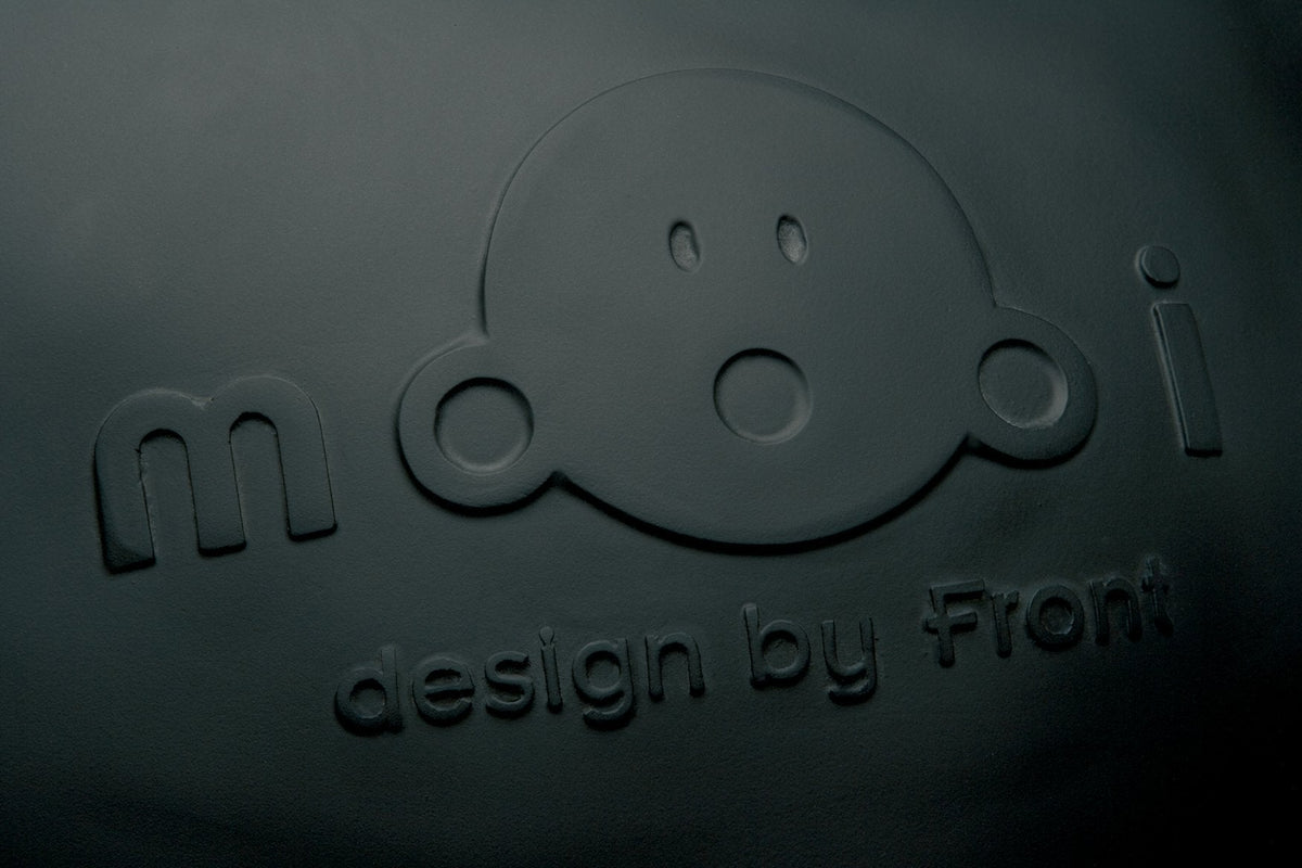 Black matte texture featuring playful embossed design of a smiling face and brand name "mooi."