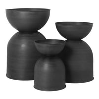 Set of three matte black ceramic vases with sleek, modern shapes and smooth finishes, perfect for a minimalist decor.