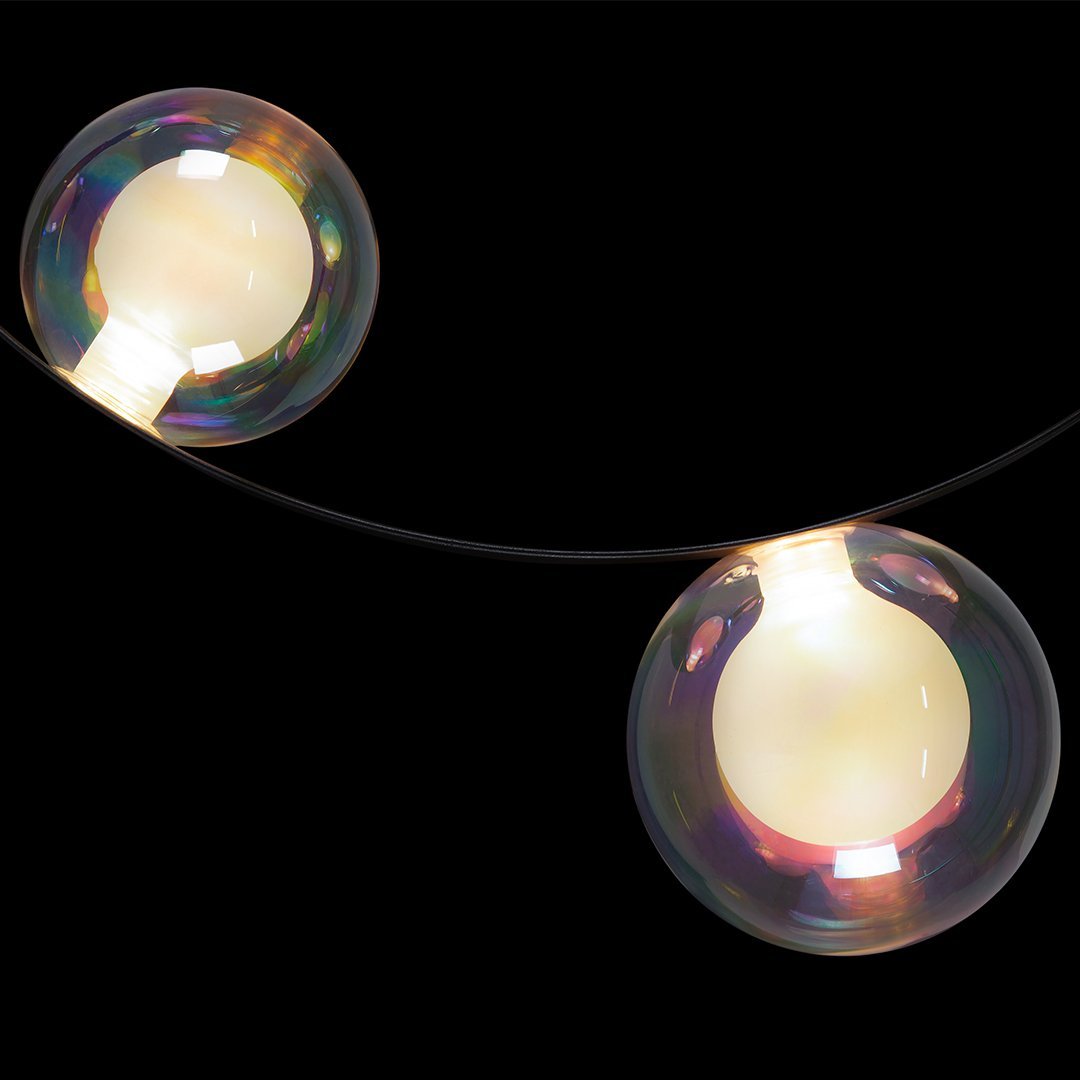 Colorful, iridescent bubble lights glowing against a dark background, featuring smooth, shiny surfaces and warm white interiors.