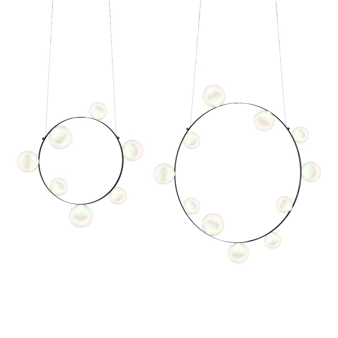 "Modern circular pendant lights in black metal with soft white globe bulbs, creating a minimalistic and elegant design."