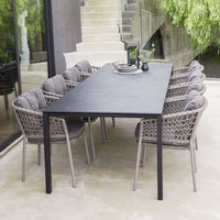 Modern outdoor dining set featuring a sleek black table and textured gray woven chairs. Ideal for stylish gatherings.