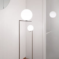 Modern floor lamp featuring two white spherical globes and a sleek, minimalist metallic frame against a neutral backdrop.