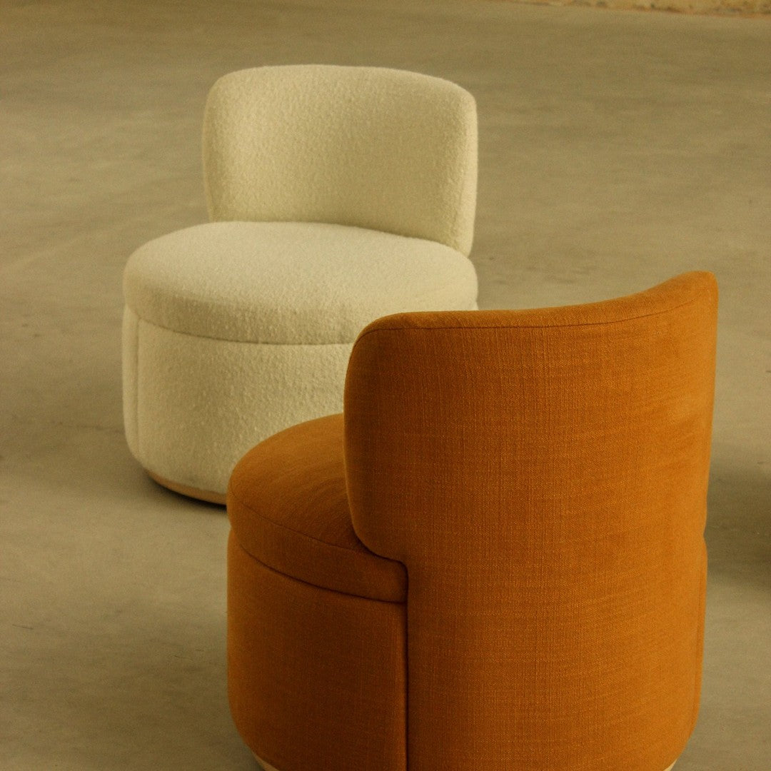 "Modern seating set featuring a cream boucle pouf and a rust-colored textured armchair, perfect for stylish interiors."