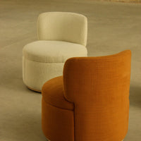 "Modern seating set featuring a cream boucle pouf and a rust-colored textured armchair, perfect for stylish interiors."