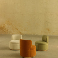 Three stylish accent chairs in orange, white, and green with smooth, modern upholstery against a neutral background.