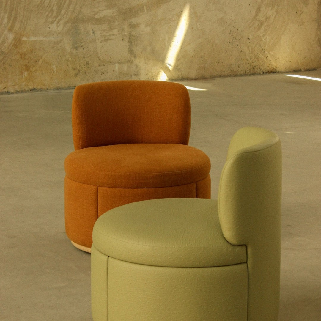 "Modern round chairs in earthy orange and soft green colors with smooth textures and minimalistic design."