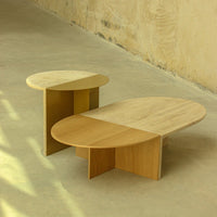 "Natural wood coffee tables with oval shapes, featuring smooth light and warm beige finishes and minimalistic design."