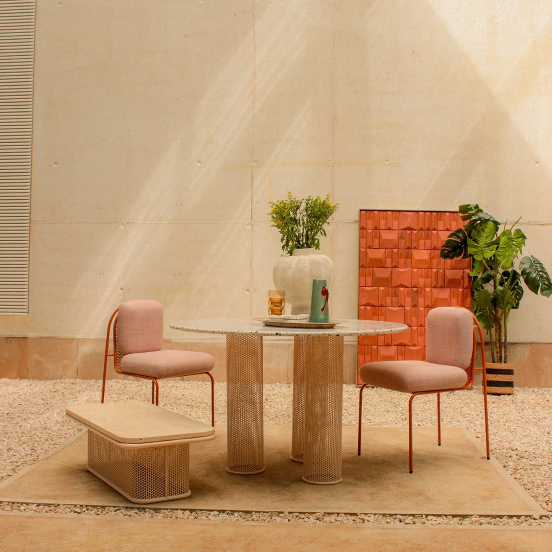 Modern dining set featuring soft pink chairs and a textured beige table, set against a minimalist backdrop.
