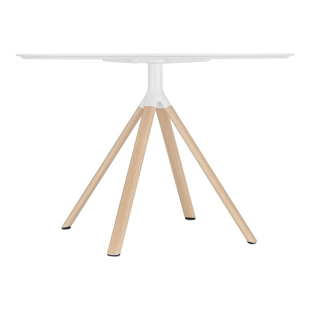 Modern white round table with natural wooden legs, featuring a minimalist design and clean lines.