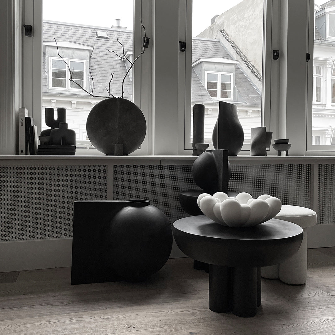 "Monochrome decor featuring black and white vases and bowls with varied shapes and textures."
