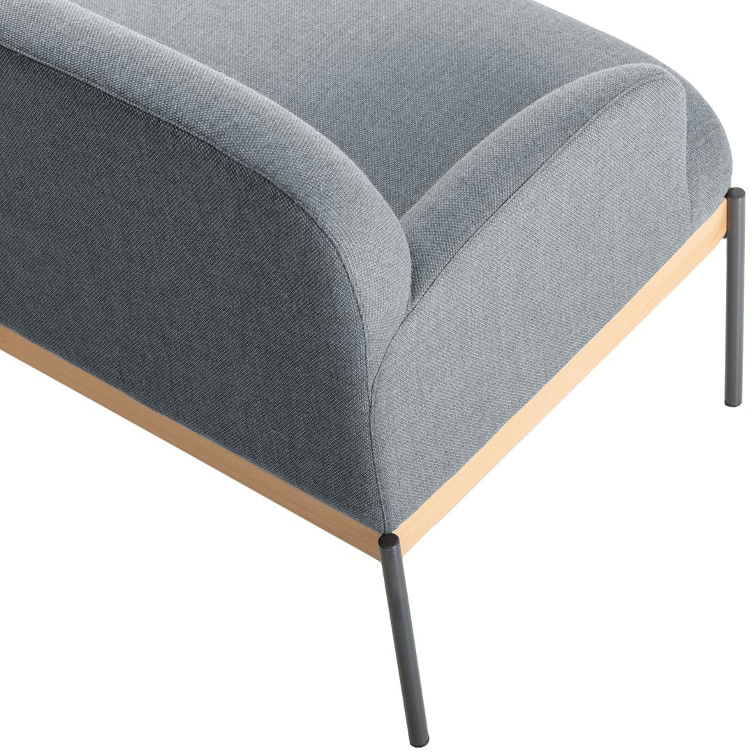 Gray upholstered sofa with a curved design, featuring a light wood base and sleek black metal legs.