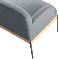 Gray upholstered sofa with a curved design, featuring a light wood base and sleek black metal legs.