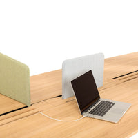 Light green and soft gray acoustic dividers on a wooden desk, complementing a sleek black laptop.