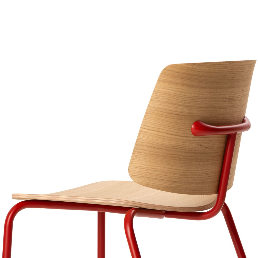 Wooden chair with a natural finish and vibrant red metal frame, featuring a smooth, minimalist design.