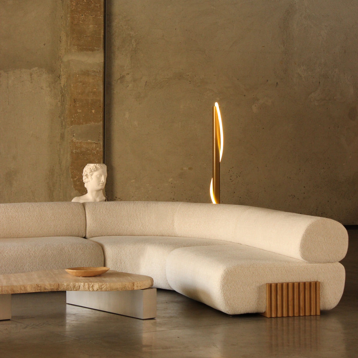Cream curvy sofa with textured fabric, wooden accents, and soft beige tones set against a minimalistic background.