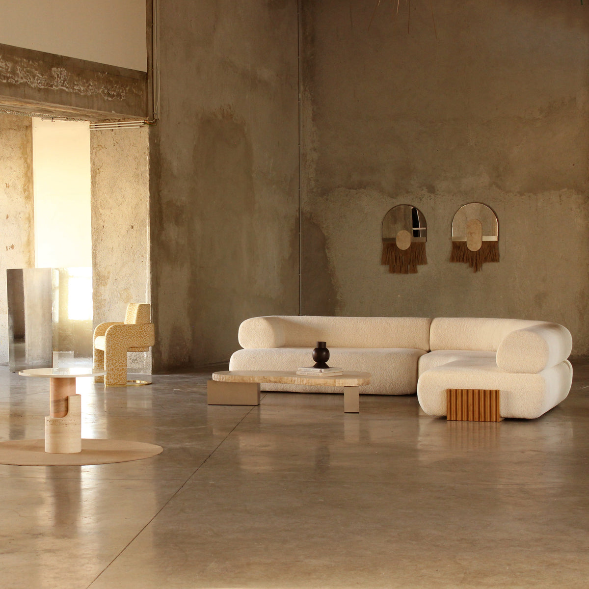 Modern living room with beige and cream colors, featuring textured fabrics and natural wood patterns.