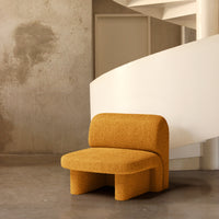 Textured mustard yellow sofa against a minimalist white spiral staircase and grey wall. Stylish, modern design.