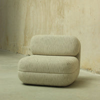 Beige striped upholstered chair with a textured pattern, featuring soft curves and a modern design.