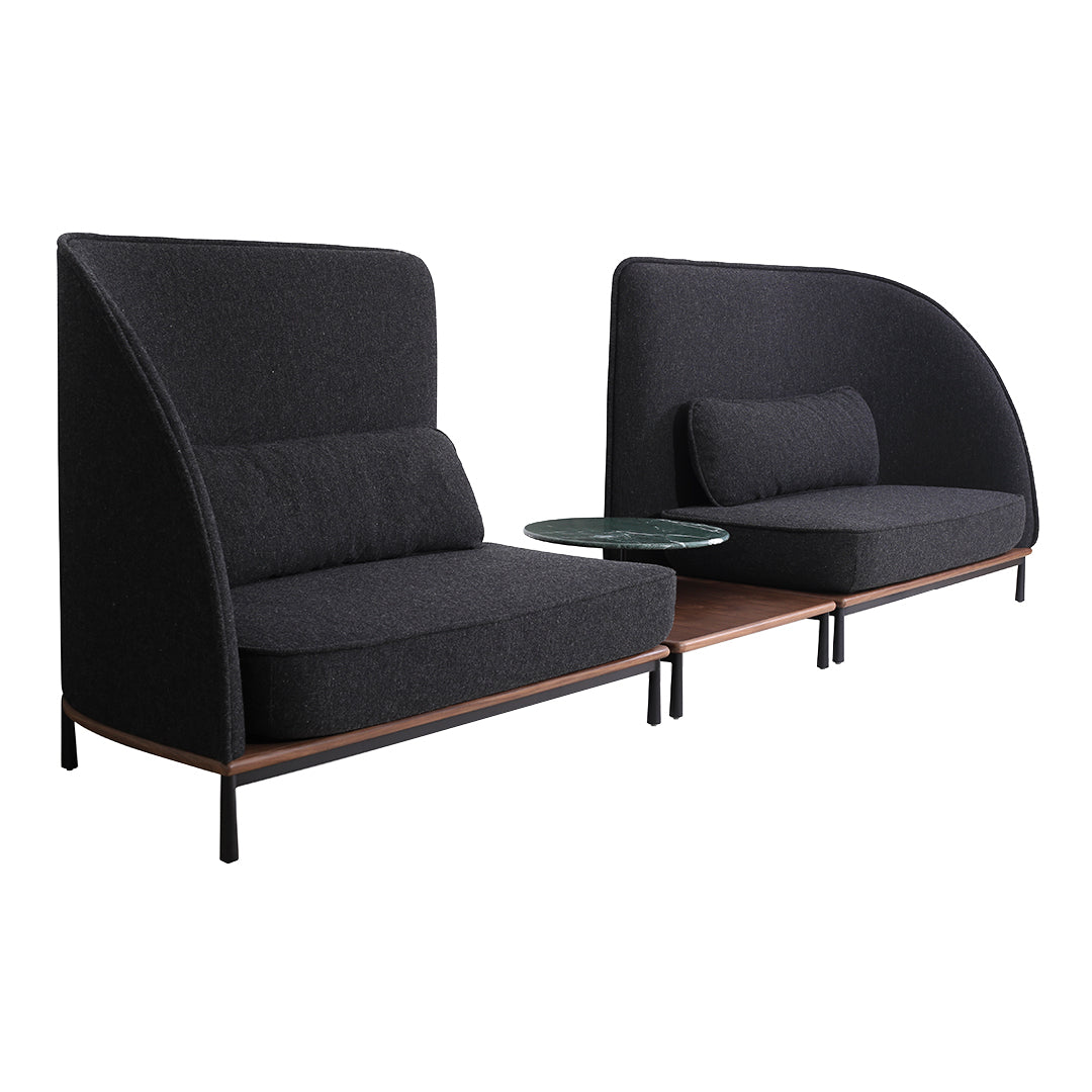 Modern black fabric sofa with smooth curved lines, featuring a minimalist wooden accent table.