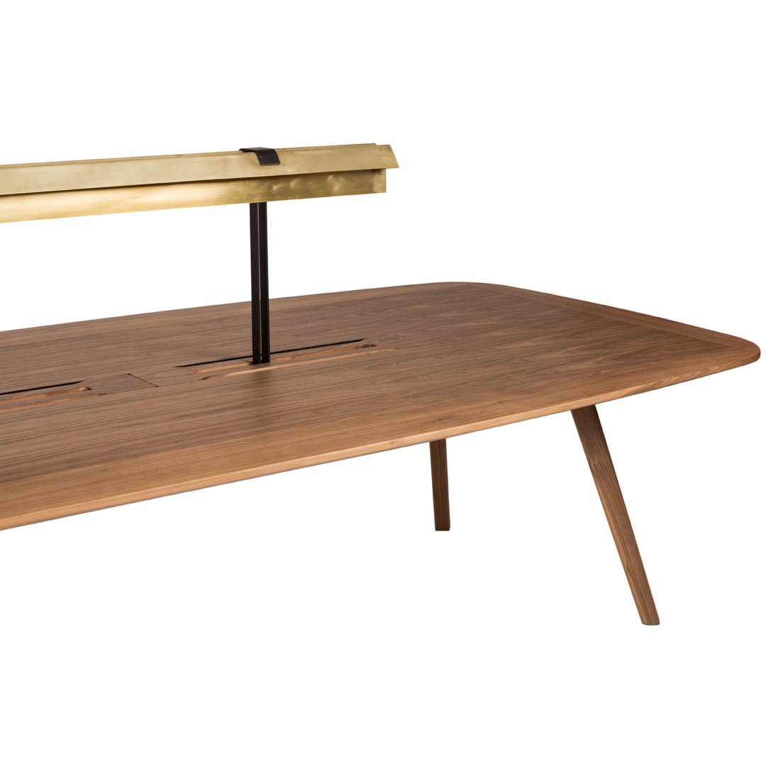 "Modern walnut table with a sleek brass accent and minimalist design, featuring a smooth, rounded surface and tapered legs."