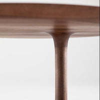 Round walnut table with a smooth finish and natural wood grain pattern, showcasing rich brown tones and elegant design.