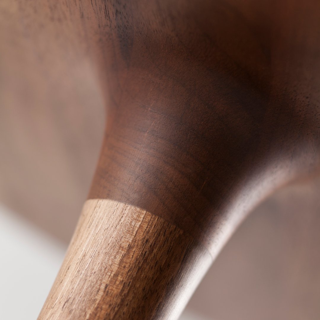 Close-up of a smooth, dark wood finish with a contrasting light wood detail, showcasing rich, natural patterns.