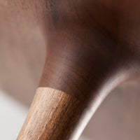 Close-up of a smooth, dark wood finish with a contrasting light wood detail, showcasing rich, natural patterns.